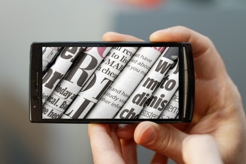 Close up of a mobile phone with a touch screen. Focus is on the phone with small DOF.
